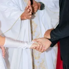 Foto das alianças nas mãos dos noivos